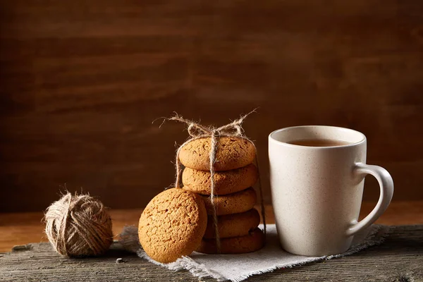 Tradizionale concetto di tè natalizio con una tazza di tè caldo, biscotti e decorazioni su un tavolo di legno, focus selettivo — Foto Stock
