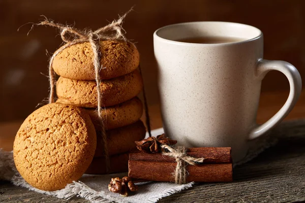 Conceito tradicional de chá de Natal com uma xícara de chá quente, biscoitos e decorações em uma mesa de madeira, foco seletivo — Fotografia de Stock