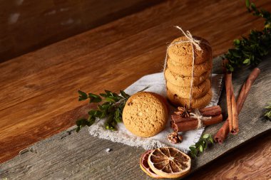 Tanımlama bilgileri, tarçın ve hafif ahşap arka plan üzerinde kurutulmuş portakal yığını ile Noel kompozisyon yakın çekim.