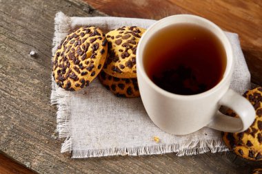 Fincan çay ve Çikolata parçalı kurabiye ülke tarzı, seçici odak beyaz saf peçete üzerinde.