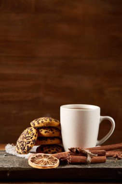 Geleneksel Noel çay bir fincan sıcak çay, kurabiye ve süslemeleri üzerinde ahşap bir masa, seçici odak konseptiyle