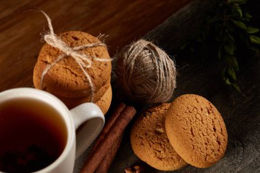 Geleneksel Noel çay bir fincan sıcak çay, kurabiye ve süslemeleri üzerinde ahşap bir masa, seçici odak konseptiyle