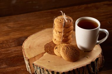 Beyaz fincan çay ve bir günlük ülke tarzı ahşap arka plan, yakın çekim, seçici odak çerezleri demet