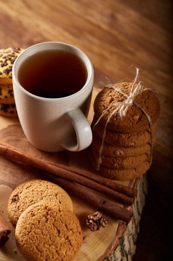 Bir fincan sıcak çay, kurabiye ve dekorasyon ahşap arka plan, seçici odak üzerinde bir oturum ile Noel kavramı