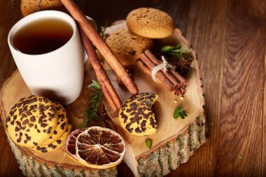 Bir fincan sıcak çay, kurabiye ve dekorasyon ahşap arka plan, seçici odak üzerinde bir oturum ile Noel kavramı