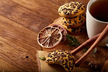 Bir fincan sıcak çay, kurabiye ve dekorasyon ahşap arka plan, seçici odak üzerinde bir oturum ile Noel kavramı