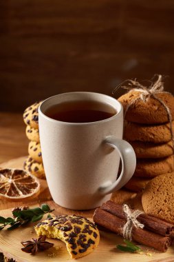 Bir fincan sıcak çay, kurabiye ve dekorasyon ahşap arka plan, seçici odak üzerinde bir oturum ile Noel kavramı