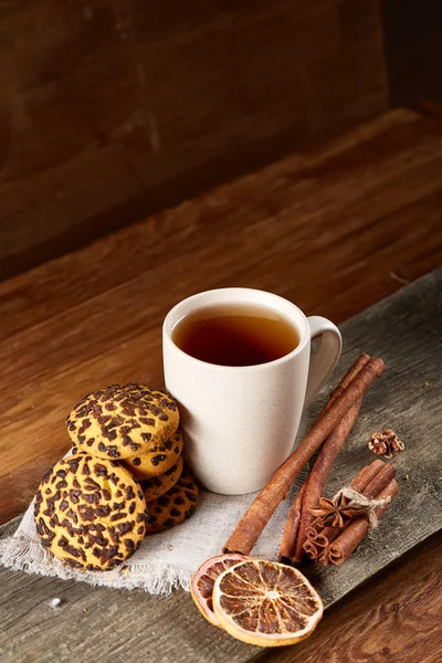 Conceito tradicional de chá de Natal com uma xícara de chá quente, biscoitos e decorações em uma mesa de madeira, foco seletivo — Fotografia de Stock