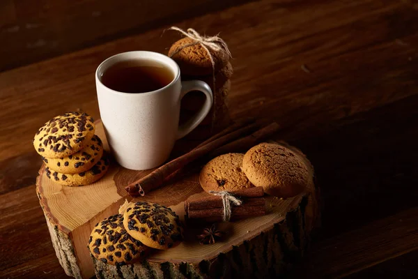 Bir fincan sıcak çay, kurabiye ve dekorasyon ahşap arka plan, seçici odak üzerinde bir oturum ile Noel kavramı