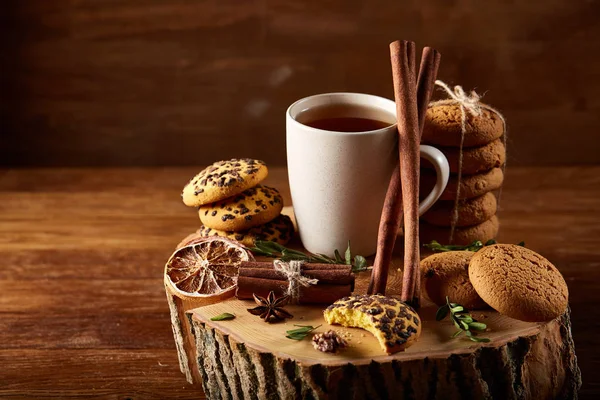 Concetto natalizio con una tazza di tè caldo, biscotti e decorazioni su uno sfondo di legno, messa a fuoco selettiva — Foto Stock