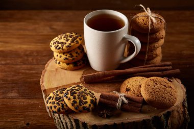 Bir fincan sıcak çay, kurabiye ve dekorasyon ahşap arka plan, seçici odak üzerinde bir oturum ile Noel kavramı