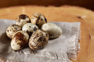 Bir günlük bir peçeteye yuvarlağına düzenlenmiş ahşap arka plan, yakın çekim, seçici odak bıldırcın yumurtası.