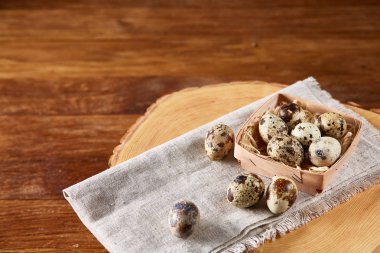 Yumurtalar bıldırcın kutusunun kompozisyon yumurta bir günlük saf bir peçeteye üzerinde ahşap arka plan üzerinde Üstten Görünüm