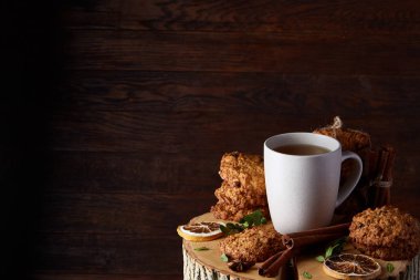 Bir fincan sıcak çay, kurabiye ve dekorasyon ahşap arka plan, seçici odak üzerinde bir oturum ile Noel kavramı