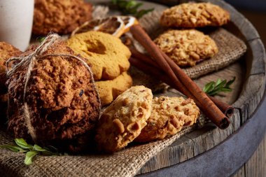 Tanımlama bilgileri ve tarçın ile ahşap bir varil, seçici odak peçeteye ürün çeşitliliği ile kavramsal kompozisyon