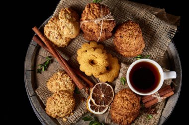 Üstten görünüm şenlikli bileşimi ile bir fincan sıcak çay, kurabiye ve spicies bir ahşap varil, seçici odak, yakın çekim