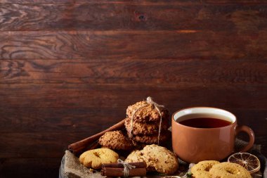 Bir kupa ile şenlikli bileşimi sıcak çay, kurabiye ve spicies bir ahşap varil, seçici odak, yakın çekim