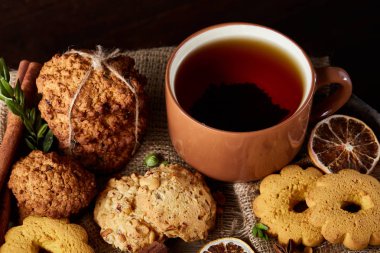 Bir kupa ile şenlikli bileşimi sıcak çay, kurabiye ve spicies bir ahşap varil, seçici odak, yakın çekim