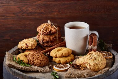 Kavramsal şenlikli bileşimi ile bir fincan sıcak çay, kurabiye ve spicies bir ahşap varil, seçici odak, yakın çekim