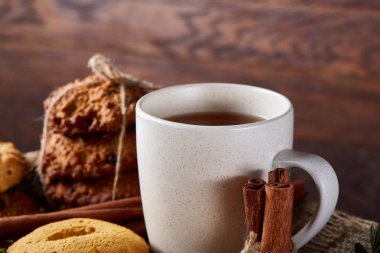 Kavramsal şenlikli bileşimi ile bir fincan sıcak çay, kurabiye ve spicies bir ahşap varil, seçici odak, yakın çekim