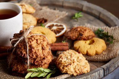 Kavramsal şenlikli bileşimi ile bir fincan sıcak çay, kurabiye ve spicies bir ahşap varil, seçici odak, yakın çekim