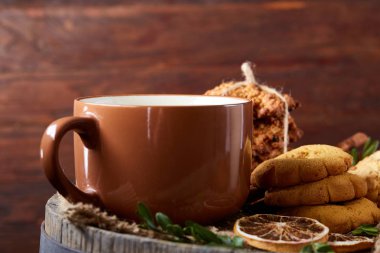 Bir kupa ile şenlikli bileşimi sıcak çay, kurabiye ve spicies bir ahşap varil, seçici odak, yakın çekim