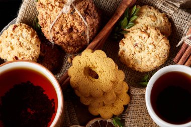 Tarçın ve iki bardak çay bir çuval bezi peçete, seçici odak, yakın çekim, üstten görünüm ile tatlılar.