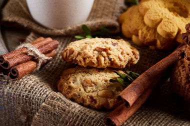Tarçın ve çay bir çuval bezi peçete, seçici odak, yakın çekim, üstten görünüm ile tatlılar.