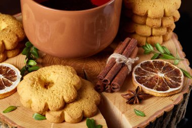 Bir fincan sıcak çay, kurabiye ve dekorasyon ahşap arka plan, seçici odak üzerinde bir oturum ile Noel kavramı