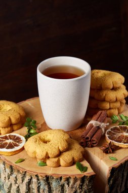 Beyaz fincan sıcak çay, kurabiye ve dekorasyon ahşap arka plan, seçici odak üzerinde bir oturum ile Noel kavramı