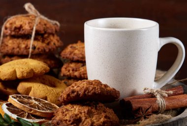 Kavramsal şenlikli bileşimi ile bir fincan sıcak çay, kurabiye ve spicies bir ahşap varil, seçici odak, yakın çekim