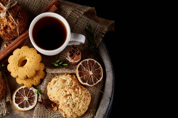 Conceptual festive composition with a cup of hot tea, cookies and spicies on a wooden barrel, selective focus, close-up — Stock Photo, Image