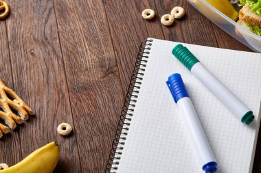 Bir defter, iki işaretleri ve ahşap bir masa, kopya alanı metin, seçici odak için çerezleri ürün yelpazesine.