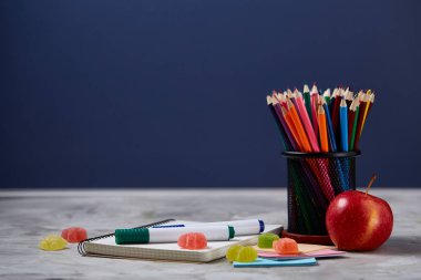 Bir defter, iki işaretleri, kalemler, beyaz bir arka plan, metin, seçici odak için kopya yer jöle fasulye ürün yelpazesine.