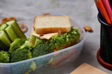 Okul veya sandviç ile öğle yemeği kutusu ve çeşitli renkli sebze ve meyve beyaz arka plan üzerinde piknik, yakın çekim.