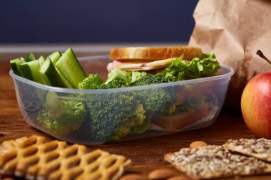 Sandviç, çeşitli sebze, meyve ve çerezleri ahşap arka plan, okul ya da piknik öğle yemeği kutu yakın çekim.