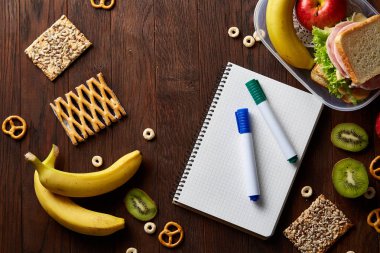 Bir defter, iki işaretleri ve ahşap bir masa, kopya alanı metin, seçici odak için çerezleri ürün yelpazesine.