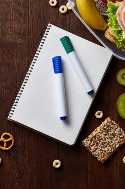 Bir defter, iki işaretleri ve ahşap bir masa, kopya alanı metin, seçici odak için çerezleri ürün yelpazesine.