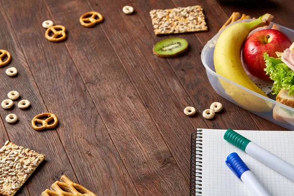 Een notebook, twee markeringen en assortiment van cookies op een houten tafel, kopie ruimte voor tekst, selectieve aandacht. — Stockfoto