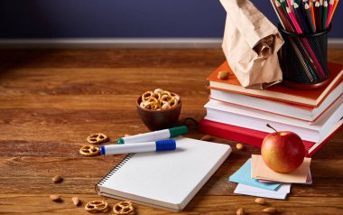 Okul öğle yemeği molası ile sağlıklı öğle yemeği kutusu ve okul malzemeleri ahşap masa, seçici odak kavramı.