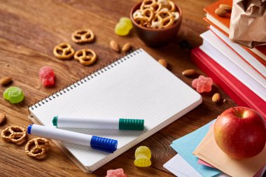 Okul öğle yemeği molası ile sağlıklı öğle yemeği kutusu ve okul malzemeleri ahşap masa, seçici odak kavramı.