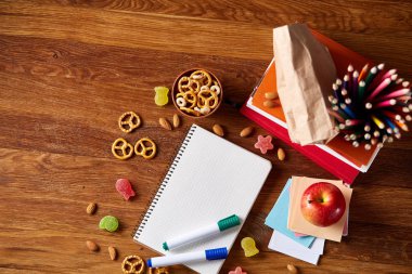 Okul öğle yemeği molası ile sağlıklı öğle yemeği kutusu ve okul malzemeleri ahşap masa, seçici odak kavramı.