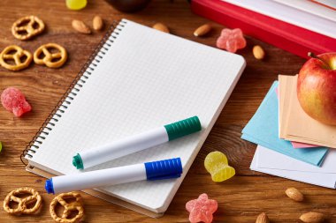 Okul öğle yemeği molası ile sağlıklı öğle yemeği kutusu ve okul malzemeleri ahşap masa, seçici odak kavramı.