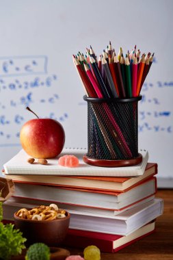 Geri okul kavramı, okul malzemeleri, bisküvi, paket öğle yemeği ve beslenme çantası beyaz yazı tahtası, seçici odak üzerinde.