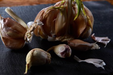 Sarımsak parçaları koyu siyah arka plan üzerine sığ derinliği alan, seçici odak, makro yakın çekim