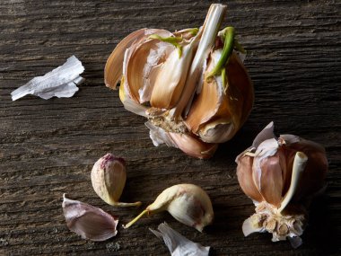 Sarımsak parçalar üzerinde karanlık kesme tahtası ahşap masa, sığ derinliği alan, seçici odak, makro yakın çekim