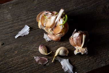 Sarımsak parçalar üzerinde karanlık kesme tahtası ahşap masa, sığ derinliği alan, seçici odak, makro yakın çekim