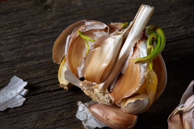 Sarımsak parçalar üzerinde karanlık kesme tahtası ahşap masa, sığ derinliği alan, seçici odak, makro yakın çekim