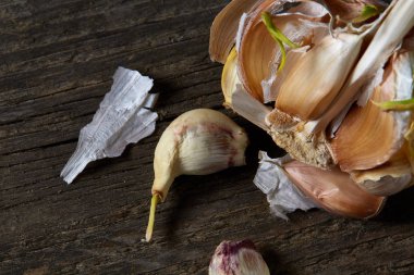 Sarımsak parçalar üzerinde karanlık kesme tahtası ahşap masa, sığ derinliği alan, seçici odak, makro yakın çekim