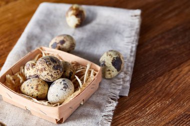 Rustik ahşap masa, yakın çekim, yüksek açılı görünüş, seçici odak kapsayıcısında bıldırcın yumurtası.